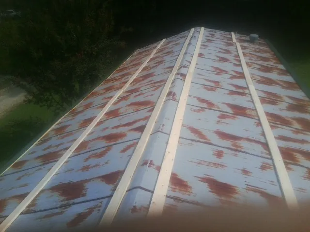 Rusted metal roof panels with new wood purlins before replacement — Storm Damage Roof Repair in Hematite by Roofing Brothers