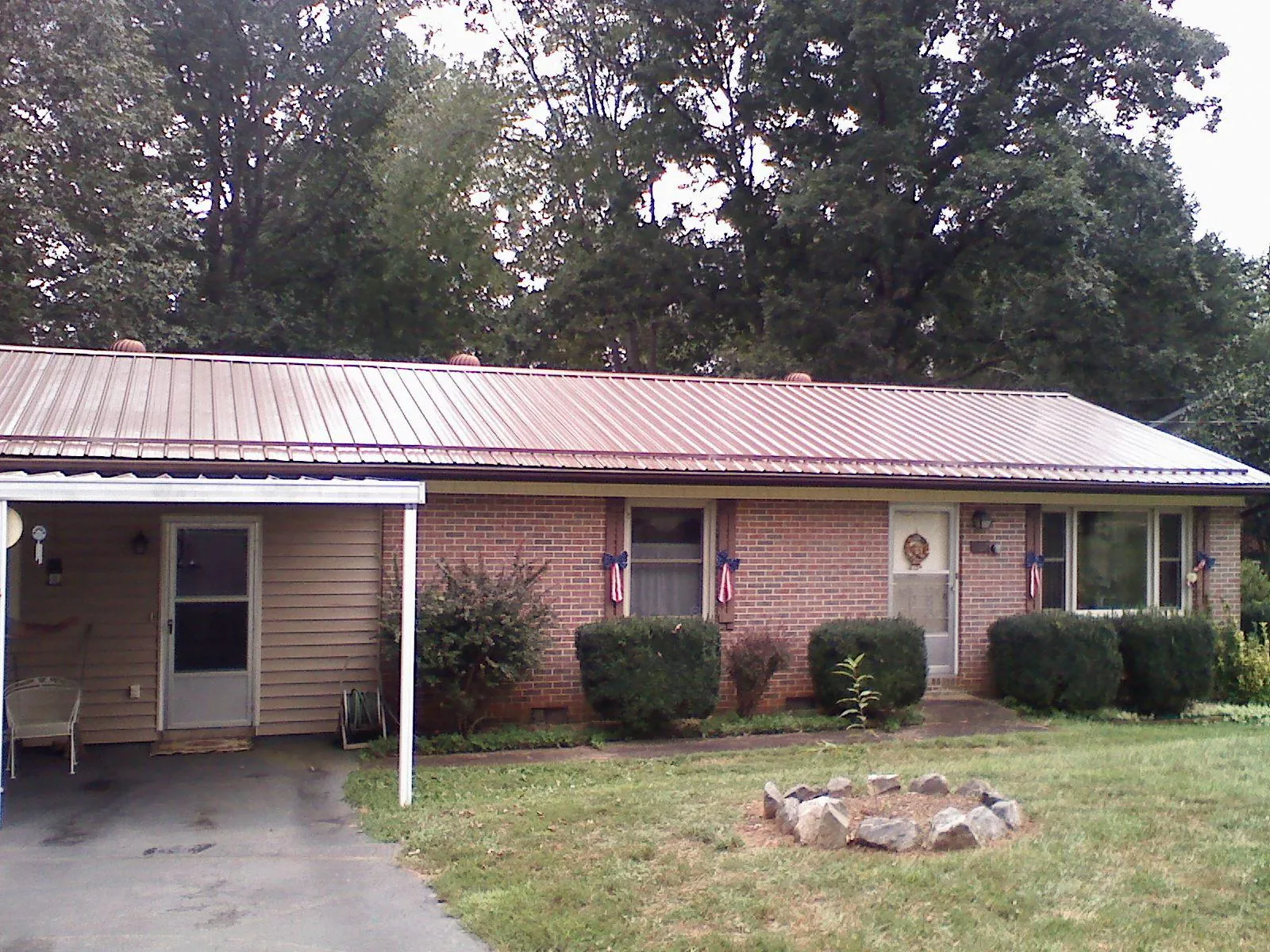 Bronze metal roof and carport on a brick ranch home — Roof Repair work by our crew in Hematite