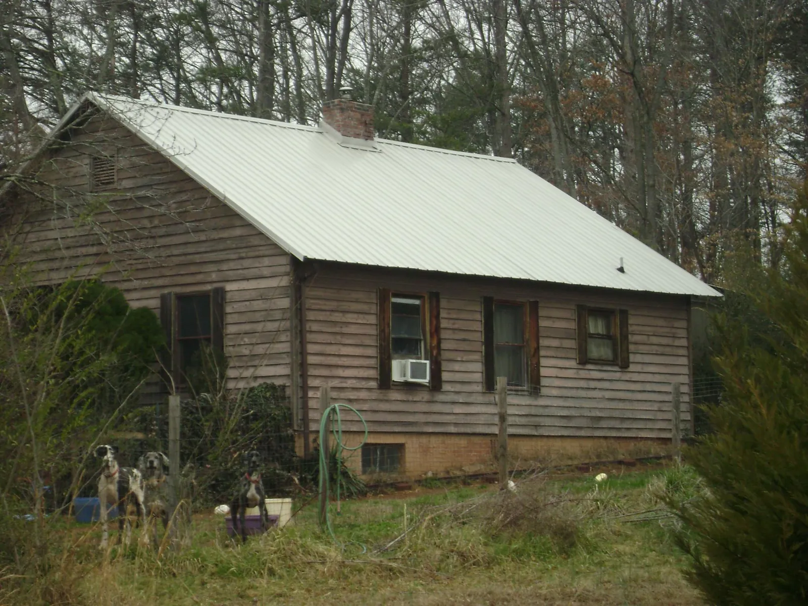 White metal roof on an old wood sided farmhouse, from a Metal Roof Installation job in Hematite